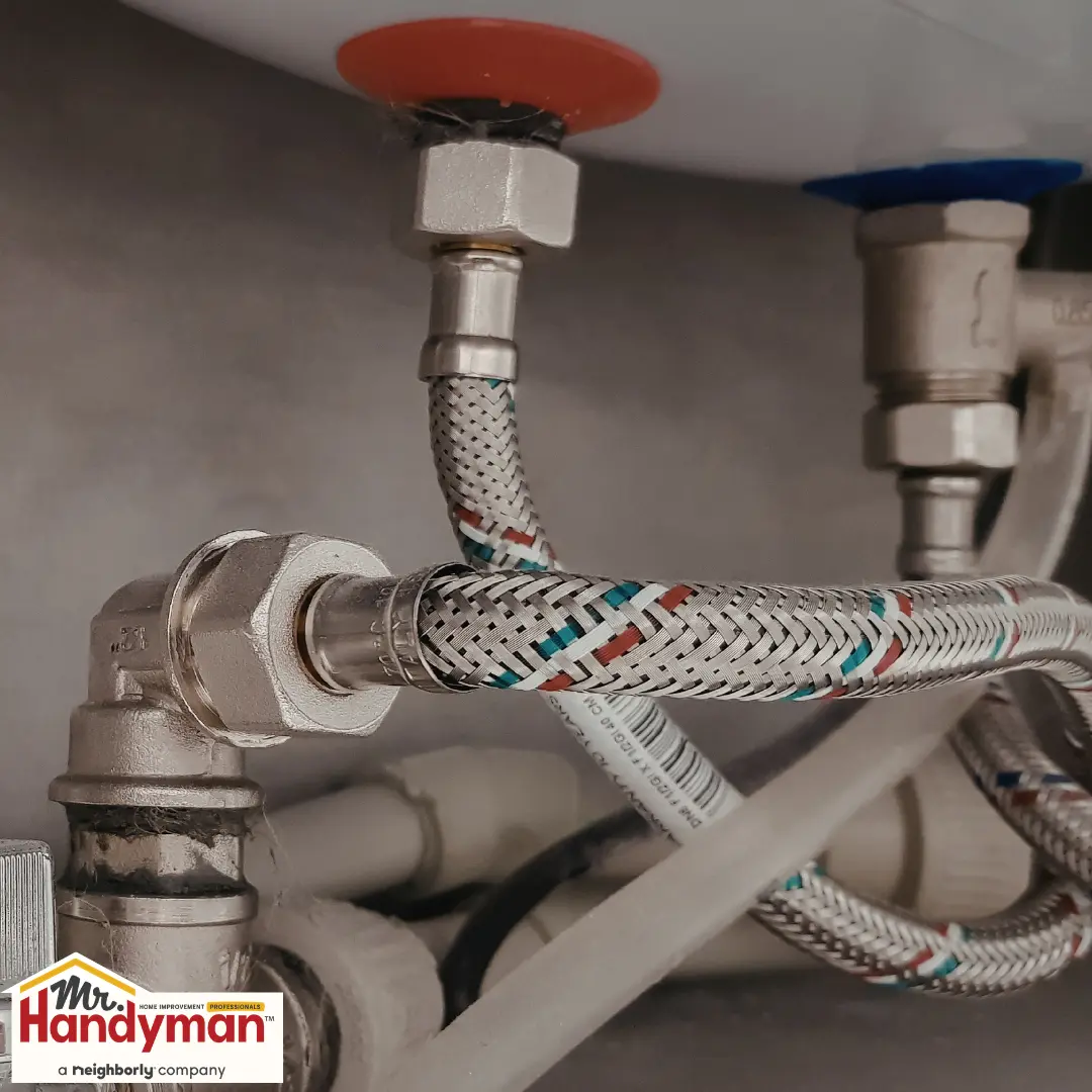 Close-up of braided flexible metal water supply hoses.