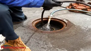 Handyman inspecting a sewer cleanout access point at a Bristol, IN home.
