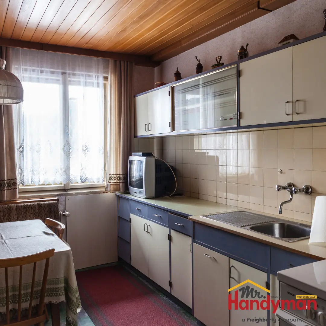 An old-fashioned kitchen features blue and white cabinets.