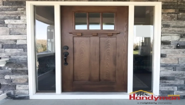 A wooden craftsman-style front door with a small window grid.