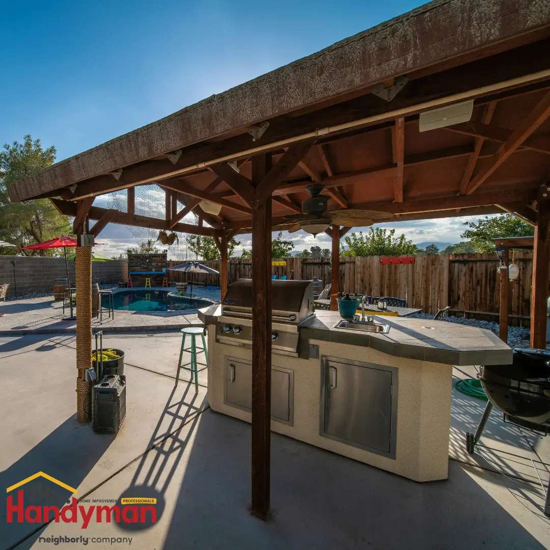 Handyman building a pergola over an outdoor kitchen.