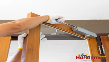 Handyman testing a deck railing for safety at a Cedar Hill, TX home.