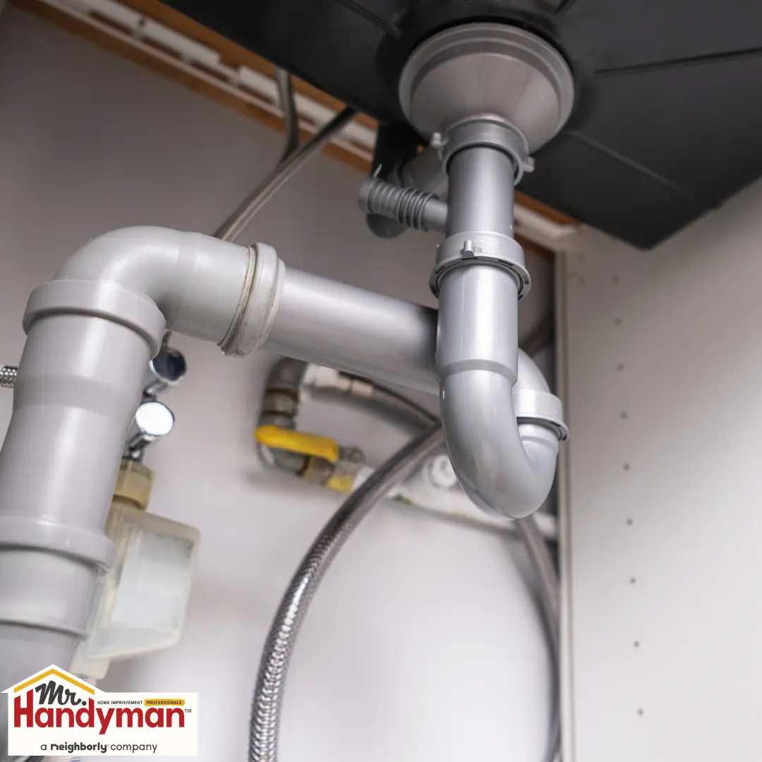Pipes and a drain trap are installed under a sink.