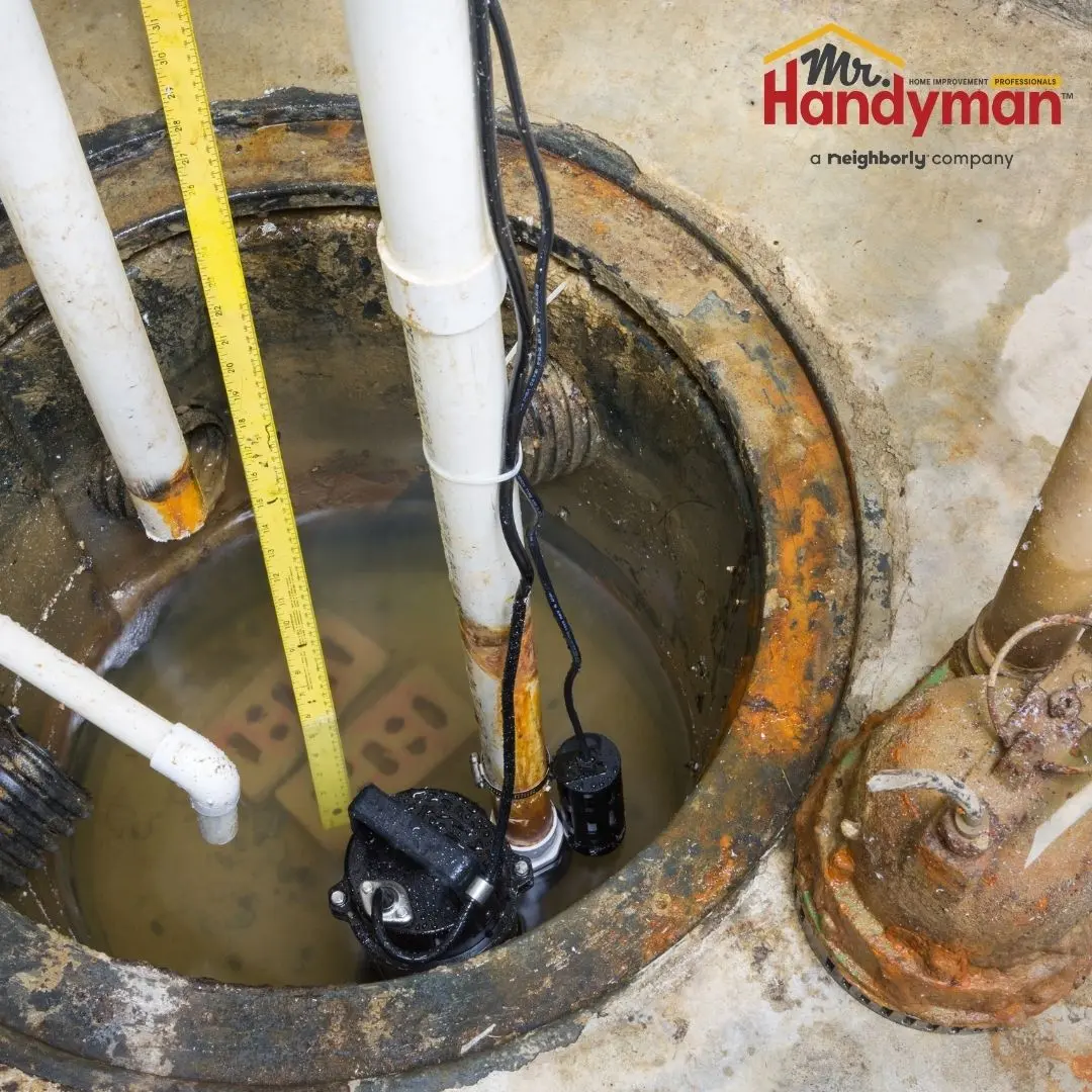 A sump pump installed in a basement sump pit, with a measuring tape indicating the water level and surrounding pipes.