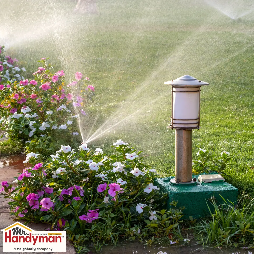 Handyman inspecting an irrigation backflow preventer at a residential property in West Nashville Tennessee