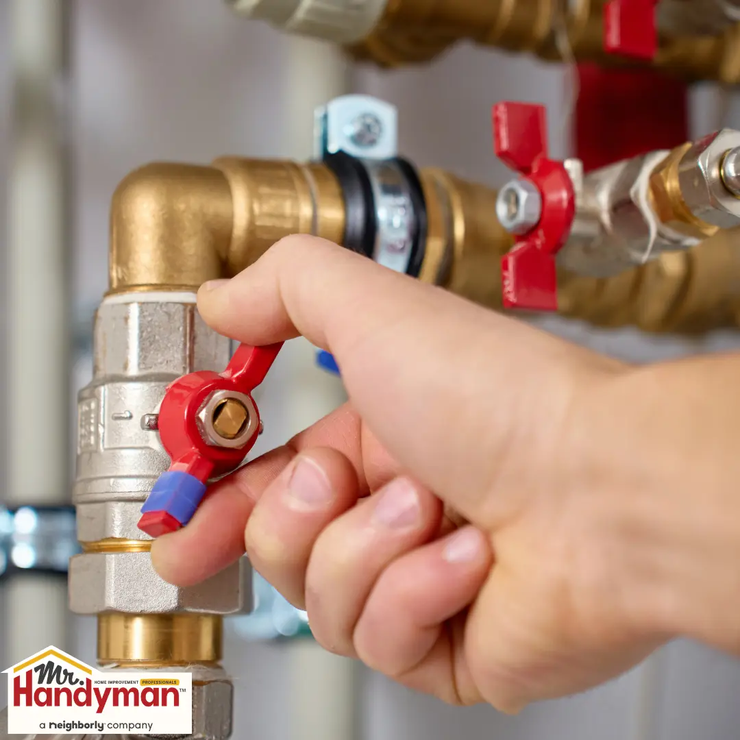 Handyman inspecting an irrigation backflow preventer at a residential property in West Nashville Tennessee
