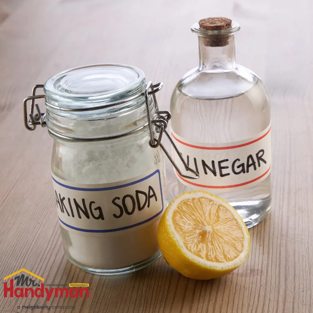 A bottle of vinegar, a jar of sugar, and a lemon.