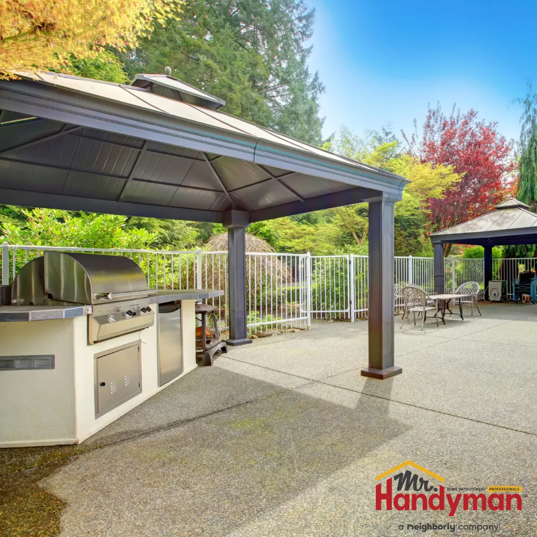 A backyard with a patio area featuring a grill.