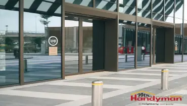 Mr. Handyman technician performing exterior maintenance and entrance door service on a commercial property in Dallas, Texas