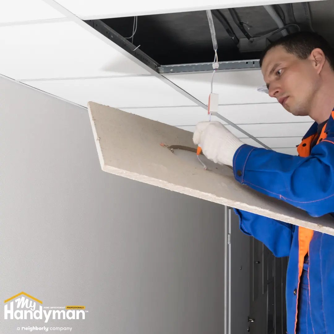 Handyman performing routine maintenance on a commercial building exterior in Ann Arbor Michigan
