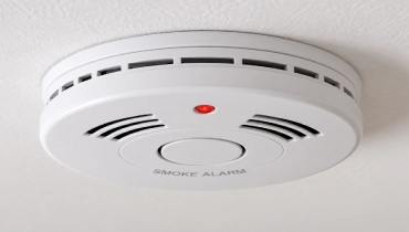 White smoke alarm mounted on a residential ceiling.