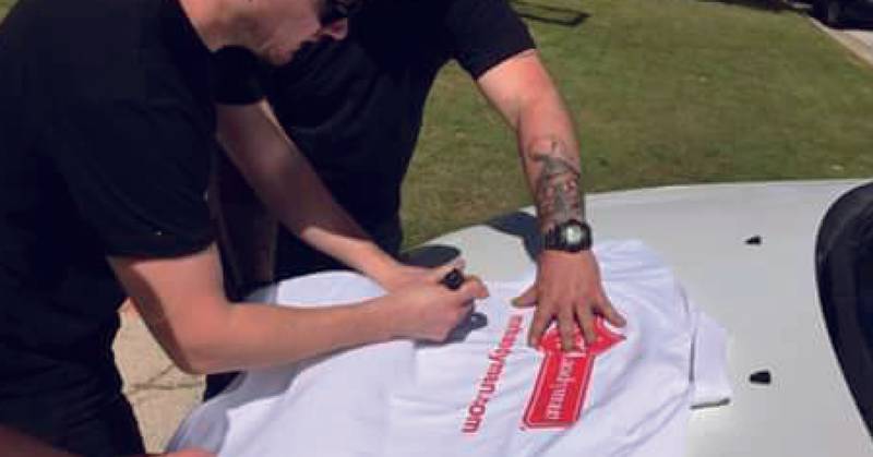 A person signing a shirt.