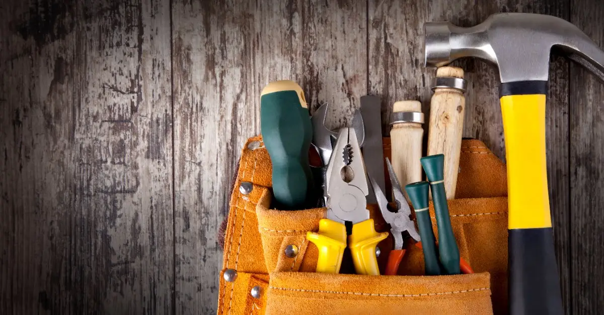 A hammer and a tool pouch with a set of tools that would be commonly used by a handyman in Alcoa, TN.