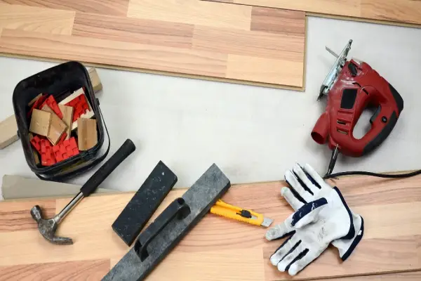 A set of carpenter’s tools lying near floor boards used for flooring installation in Charleston, SC.