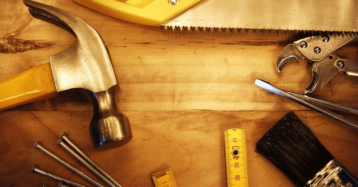 A hand saw, hammer, and other tools that may be used by a handyman in Fairview Heights, IL.