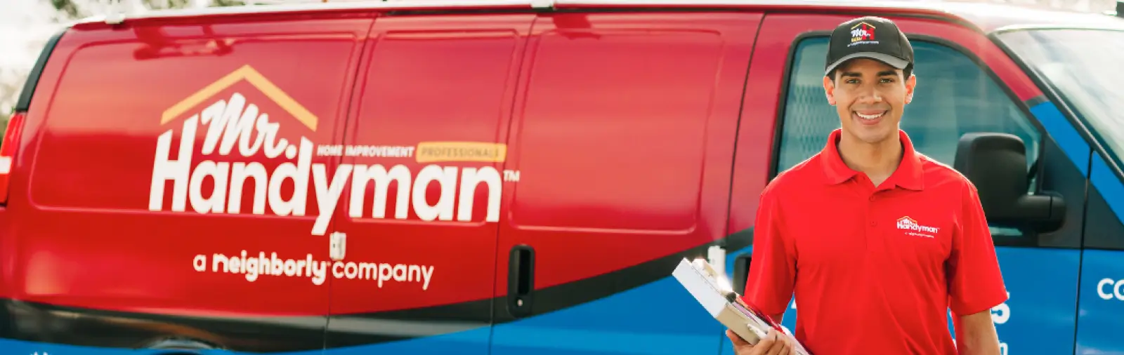 A Mr. Handyman service professional standing next to a work van.