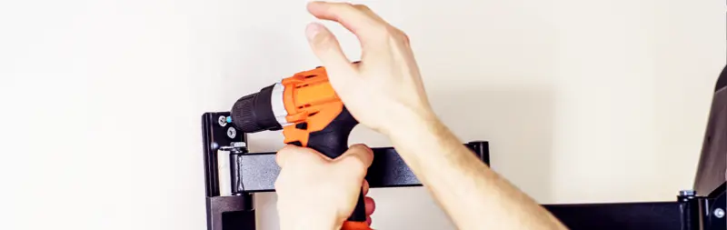 A TV wall mount being installed.