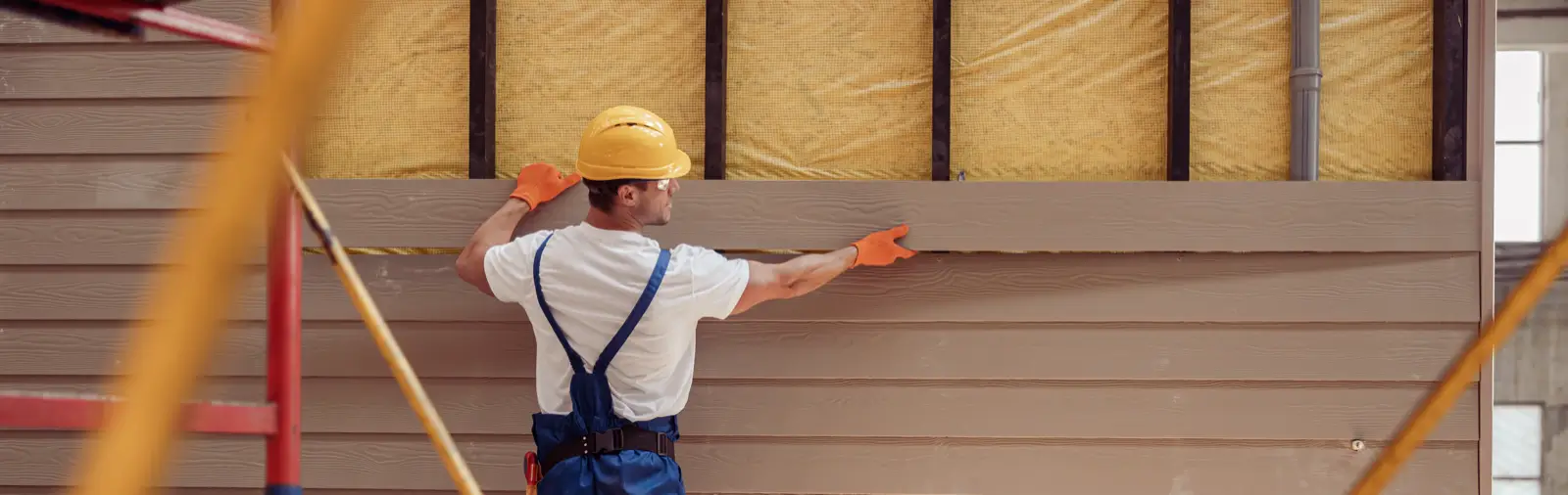 A construction worker installing siding