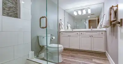A newly completed bathroom remodel in Charleston, SC with white shower tiles in a standing shower and a large mirror installed above a double-vanity