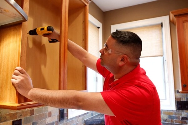  Handyman installing cabinets during kitchen remodeling in Brighton, CO
