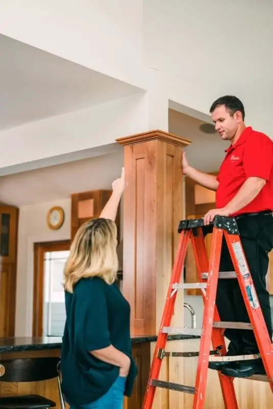 Mr. Handyman discussing crown molding & trim painting with woman