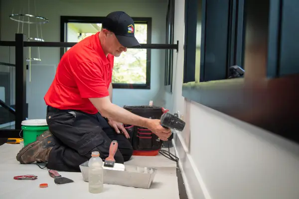  handyman performing drywall repair on the ceiling