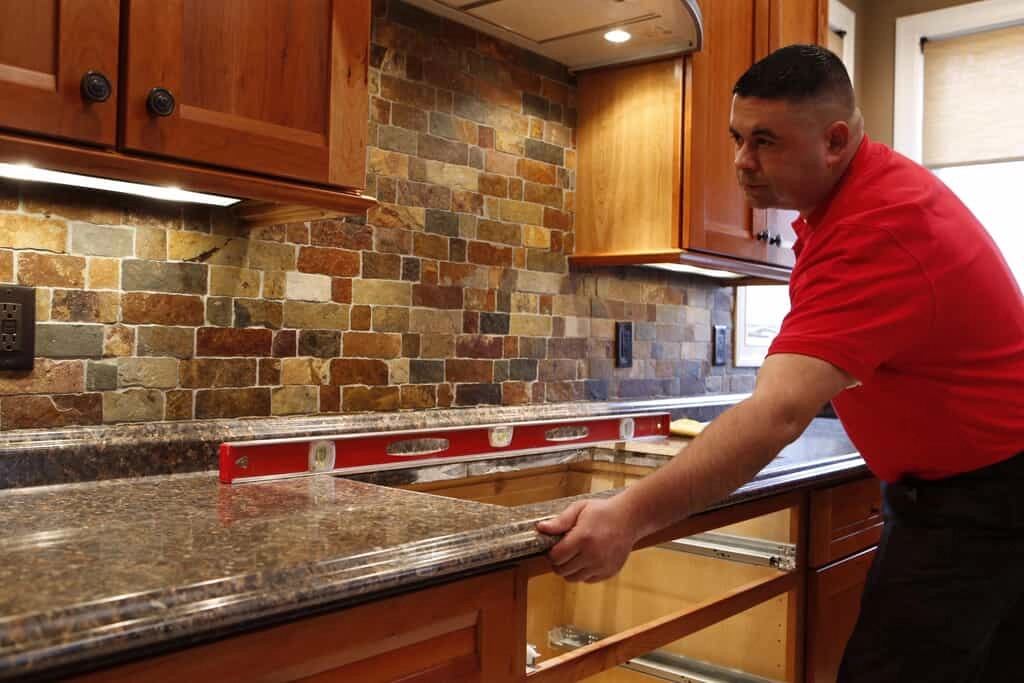 A handyman from Mr. Handyman installing a new countertop during a Lewisville home remodeling project.