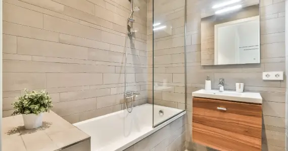A newly remodeled modern shower with a glass wall installed with professional services for shower remodeling in Cincinnati, OH.