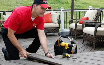 Mr. Handyman technician repairing wood deck.