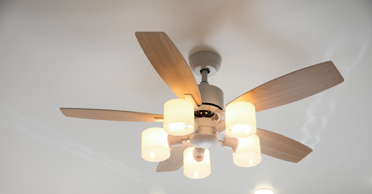 A five-blade ceiling fan with five built in lights on a residential ceiling after ceiling fan installation has been completed.