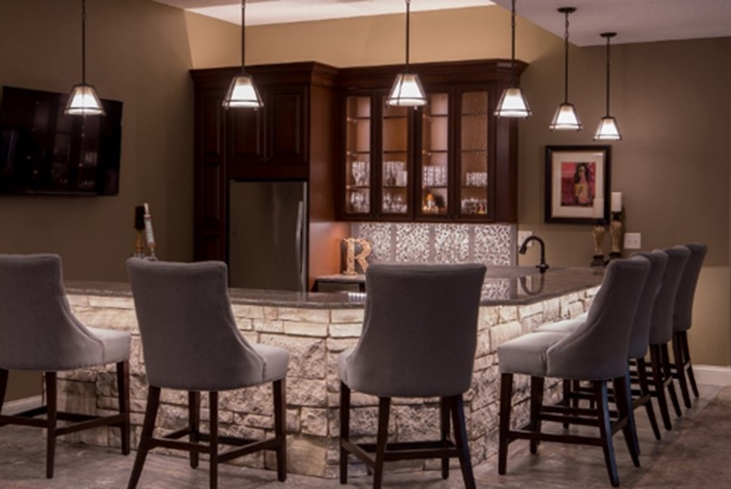 A kitchen countertop with several hanging lights installed above it to improve lighting around the kitchen and reduce aging in place challenges for those with impaired vision.