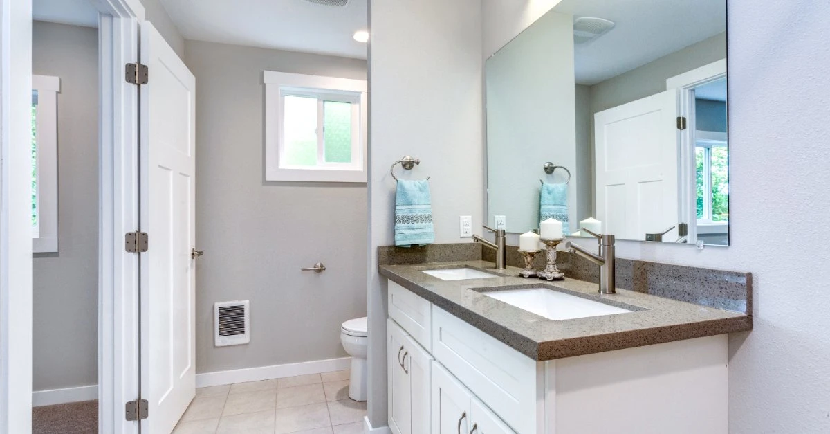 A modern bathroom with new countertops, cabinets, and floor tiles installed during a bathroom remodel in Naples, FL.