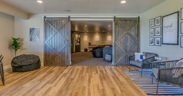 Two rooms in a basement separated by sliding barn doors after each room has been updated with a basement remodel in Wichita, KS.