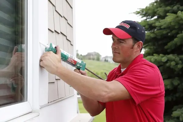 Mr. Handyman technician caulking window to make sure it is leak and air proof in Colorado Springs