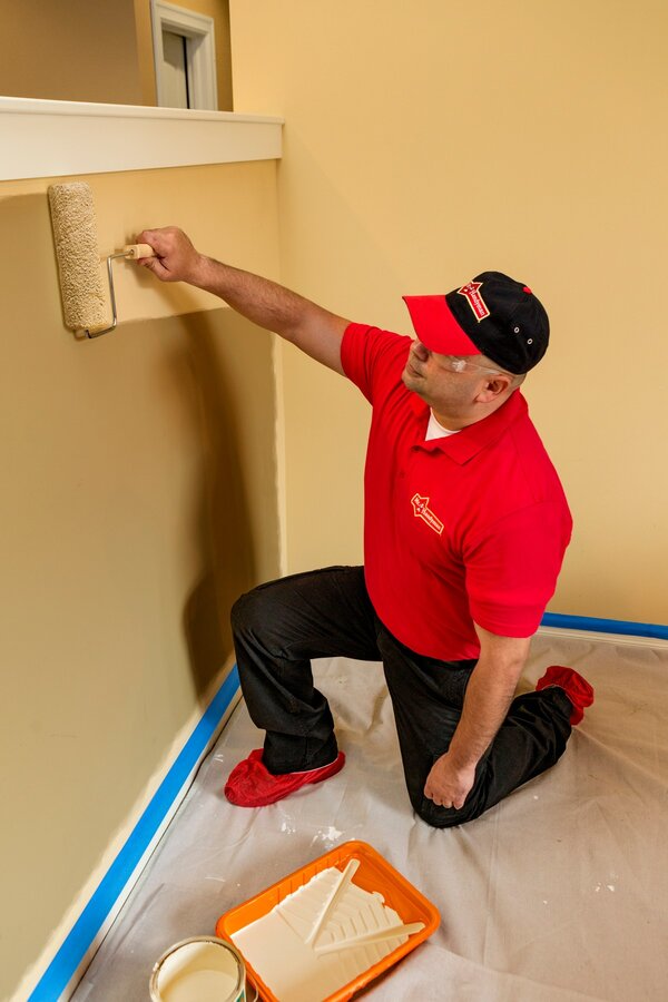 Mr. Handyman technician painting interior of Saratoga Springs home with a paint roller