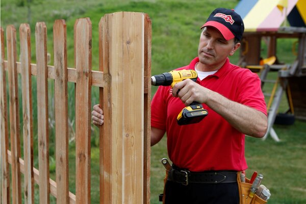 Mr. Handyman installing fence in Boulder with drill.