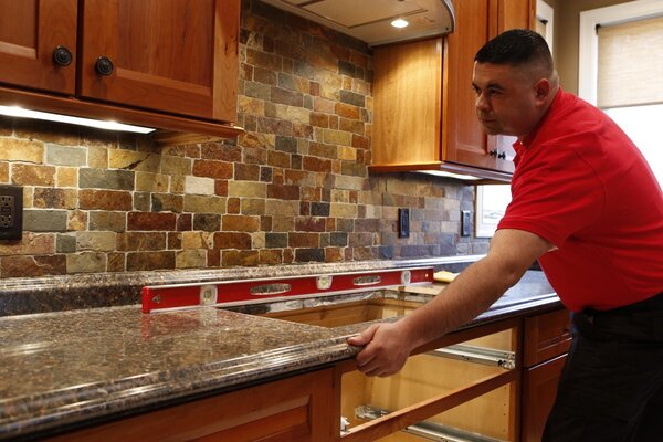 Mr. Handyman technician making sure newly installed countertops are level during a Boulder kitchen remodel
