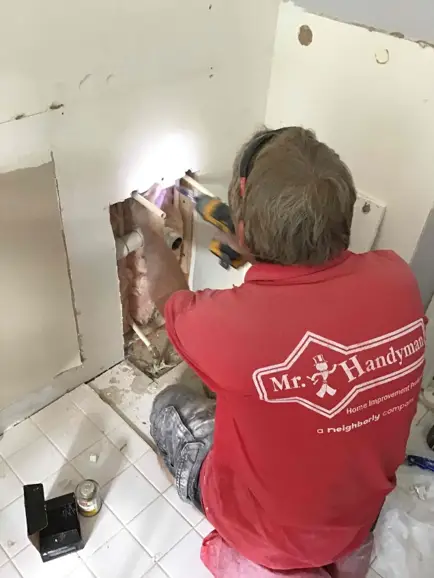 Mr. Handyman employee working on drywall