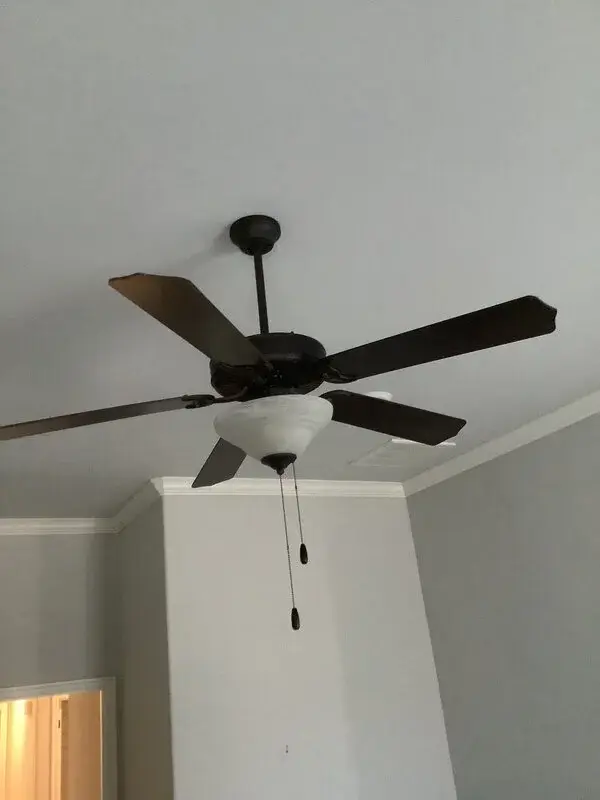 A 5-blade ceiling fan installed on the ceiling of a home by Mr. Handyman.