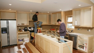 Handymen remodeling a kitchen inside a home