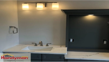 Bathroom vanity with modern triple light fixture installed by Mr. Handyman of Martinsburg and Charles Town.