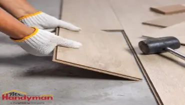 Mr. Handyman technician installing luxury vinyl plank flooring in a Plano, Texas home.