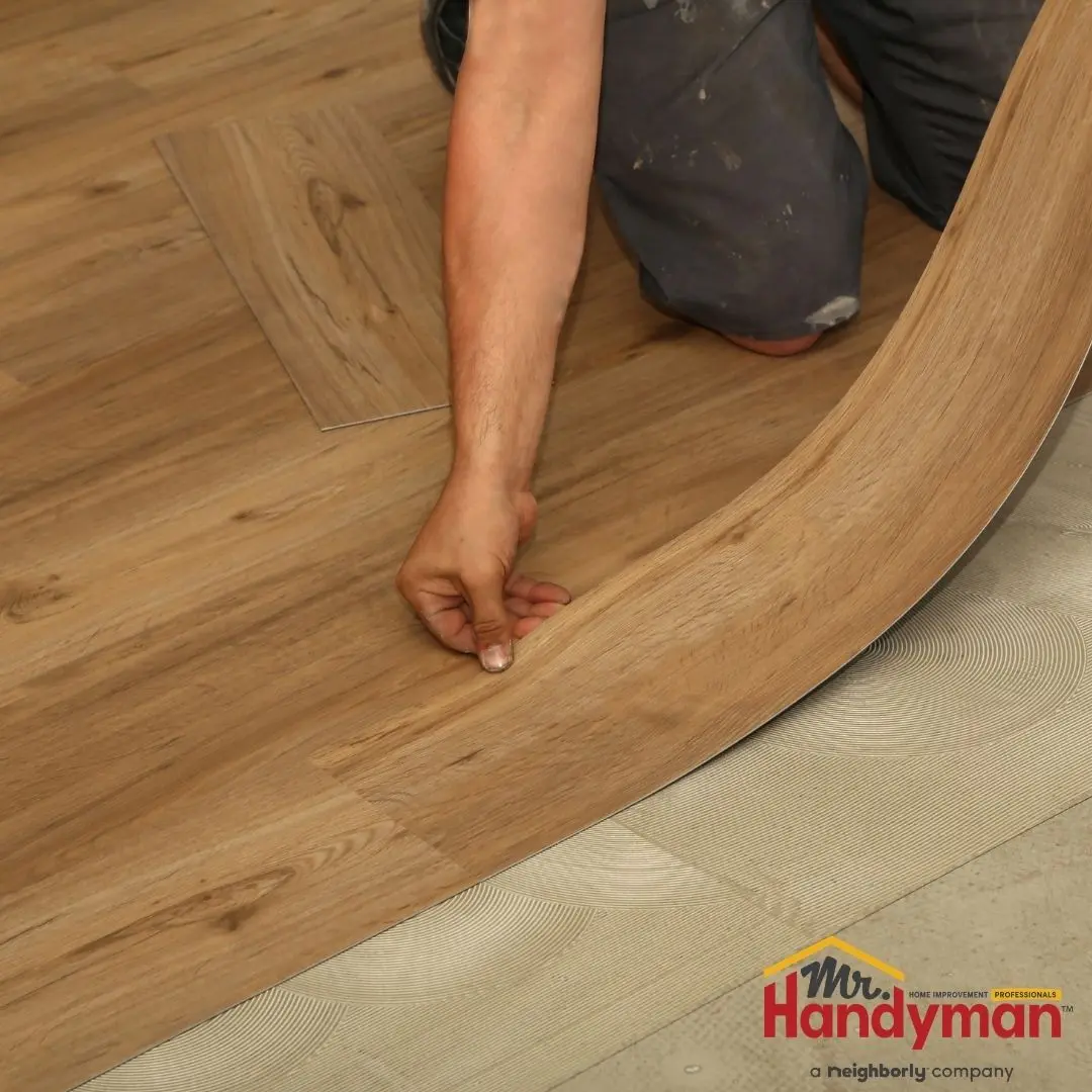 Mr. Handyman technician installing luxury vinyl plank flooring in a Plano, Texas home.