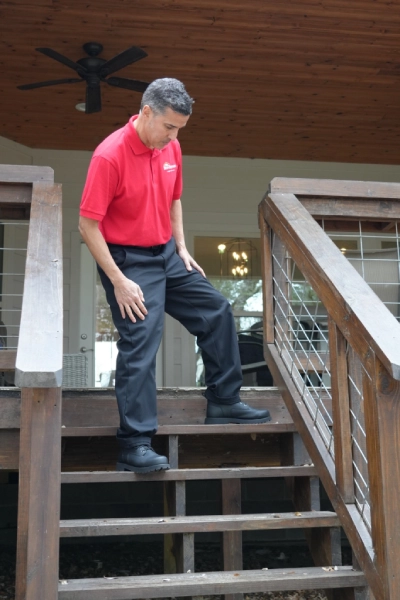 Mr. Handyman service professional inspecting outdoor stairs and handrails.