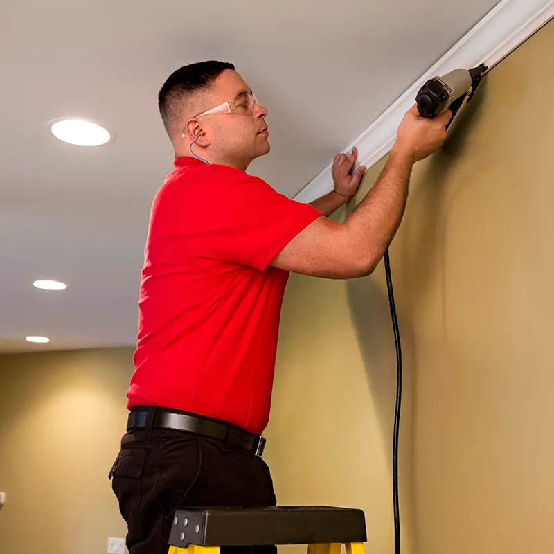 A Mr. Handyman technician installing crown molding.