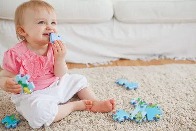 baby on floor with toys