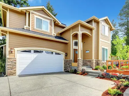 two story tan home with landscaping