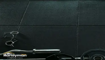 Handyman repairing damaged rubber gym flooring in a commercial fitness facility in Murfreesboro TN