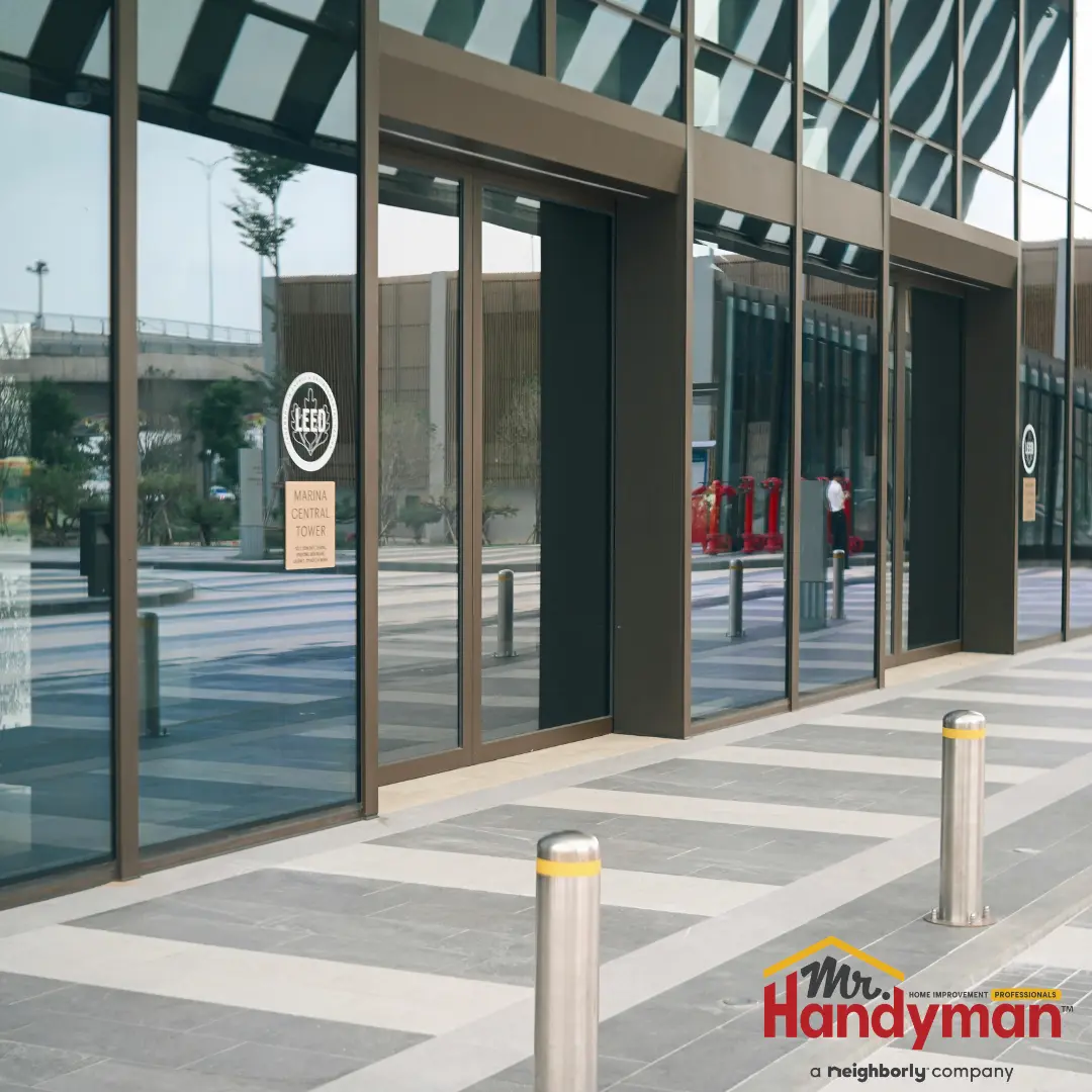 Mr. Handyman technician cleaning exterior surfaces and servicing entry doors at a commercial property in Martinsburg, West Virginia