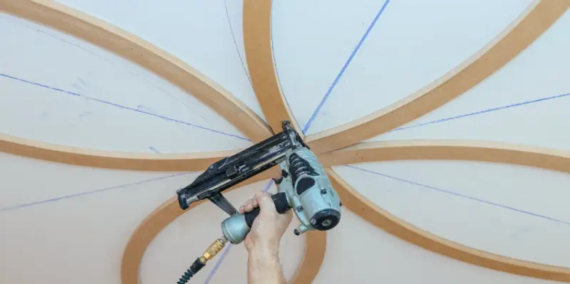Curved wooden beams being installed as part of residential ceiling&rsquo;s finish carpentry in Flower Mound, TX.